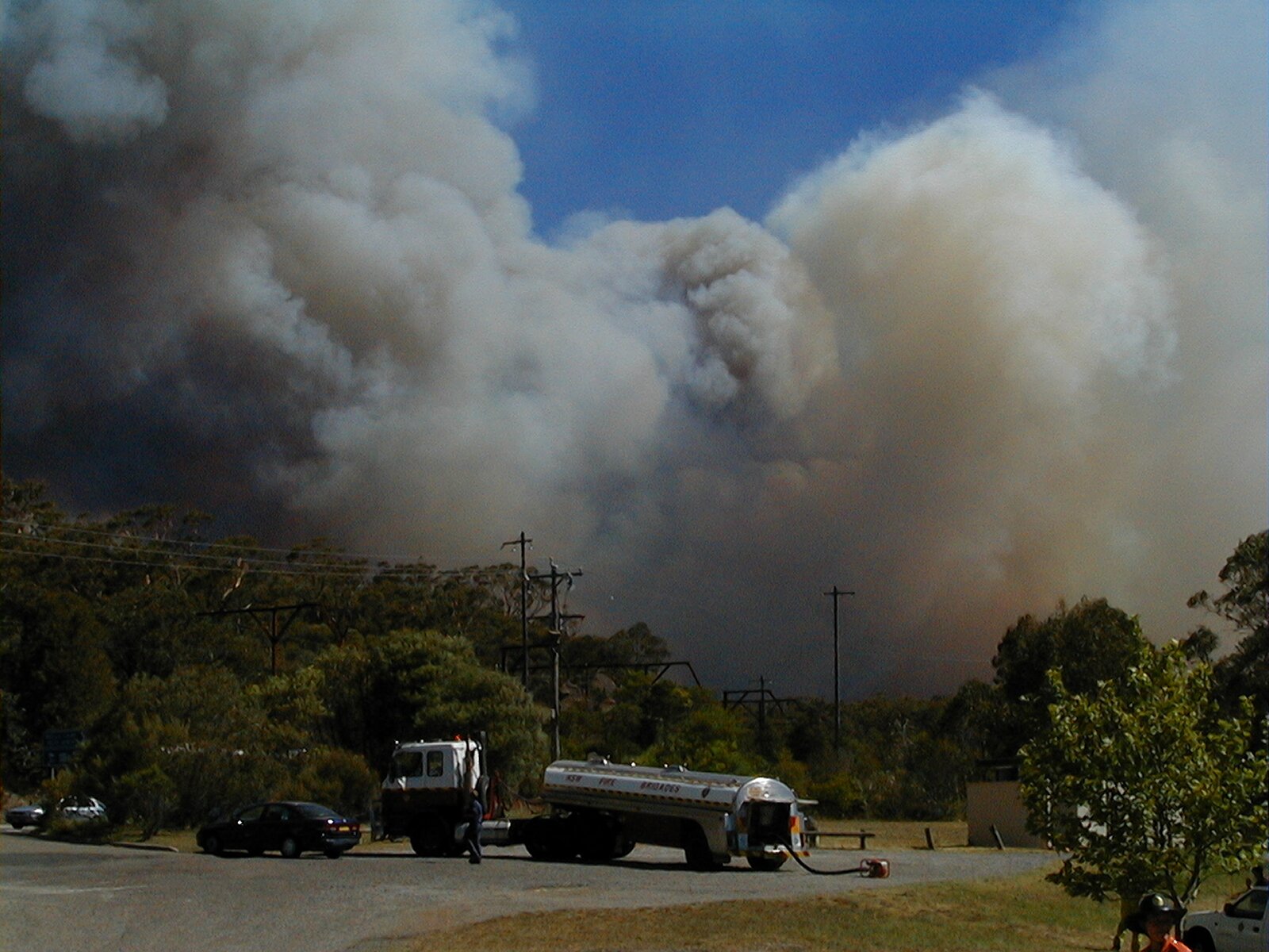 A huge smoke column towering over the same staging area a few minutes later